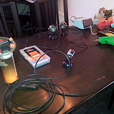 Op de tafel liggen kabels, lampjes en gereedschap.